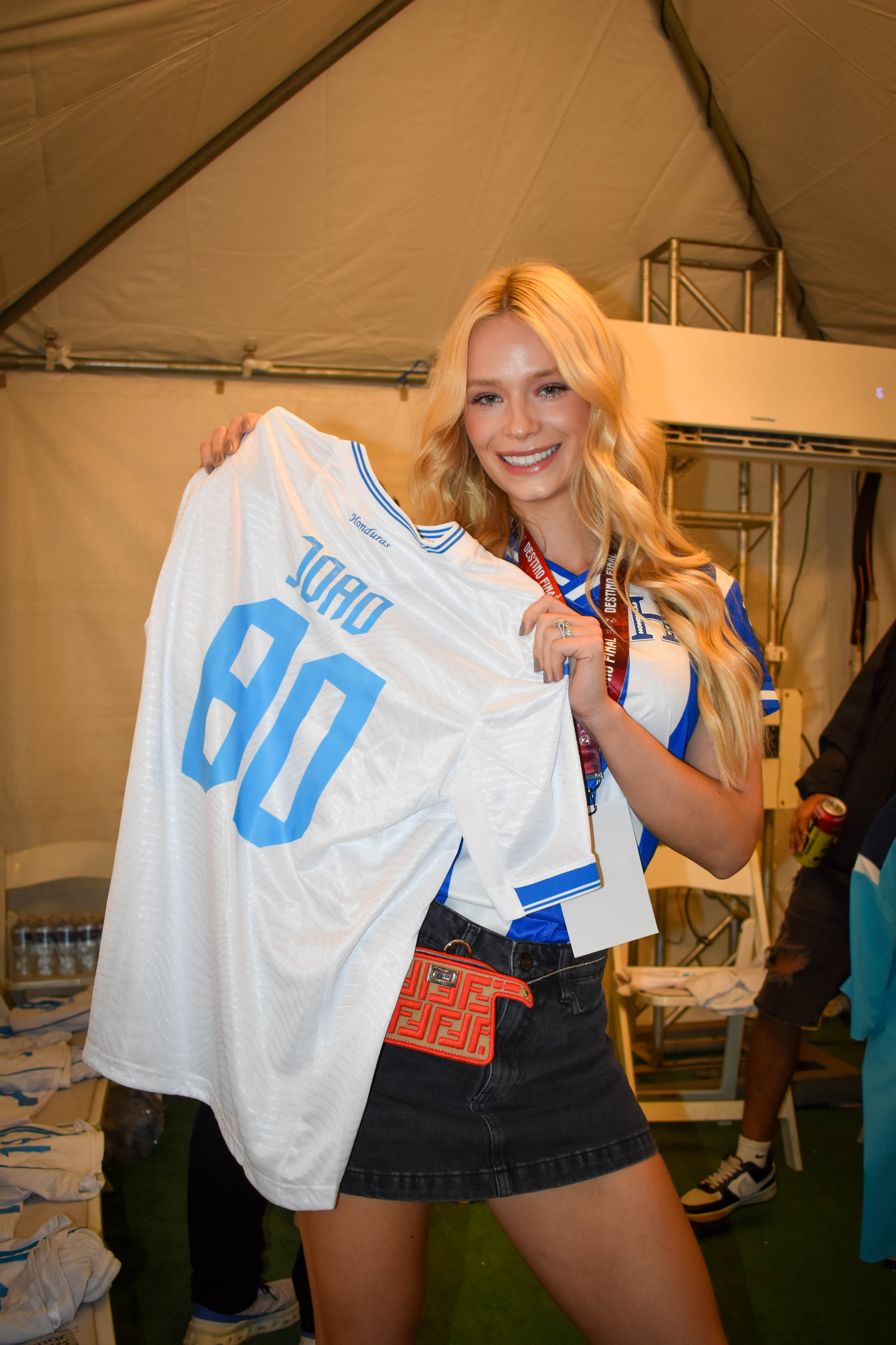 A studio portrait lit in warm tungsten — a young woman in profile against a deep charcoal seamless, soft fall-off on her shoulder, signature Brivon lighting.